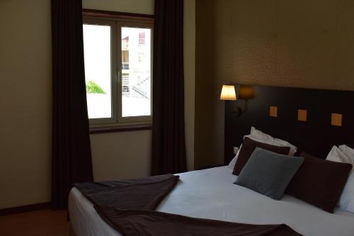 雷森迪Douro Marina Hotel & SPA的一间卧室设有一张大床和窗户