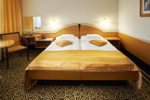 罗斯诺夫·波德·拉德霍斯滕艾尔罗普兰康体酒店的酒店客房设有一张大床和一张桌子。