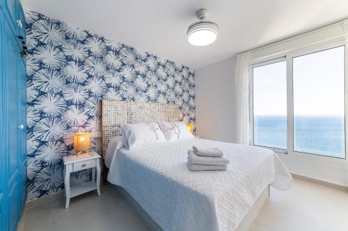 阿尔么丽亚Los acantilados的一间卧室配有一张蓝色和白色壁纸的床
