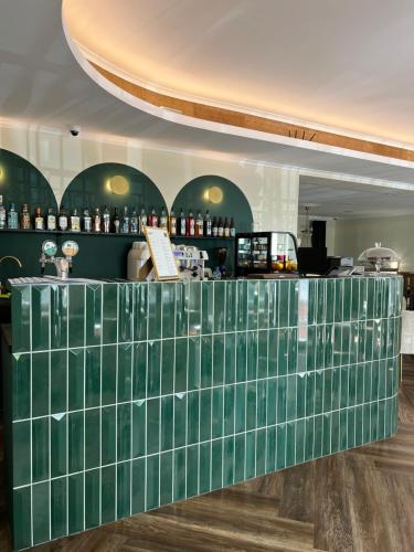 ChludowoMleczarnia Hotel Restauracja的带酒吧的客房内的绿色瓷砖柜台