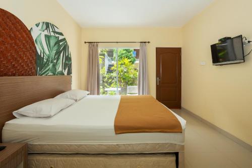 塞米亚克Cove Kanaya的一间卧室设有一张带电视和窗户的床。