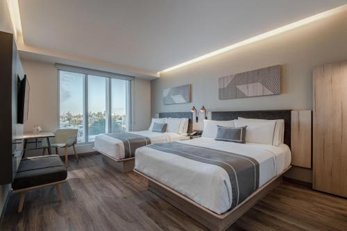 墨西卡利City Express Plus by Marriott Mexicali的酒店客房配有两张床和一张书桌