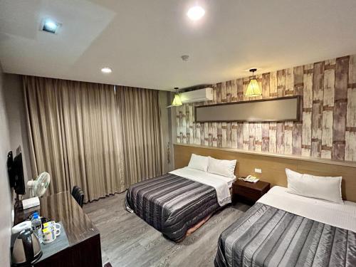 金城宏福旅店的一间酒店客房,设有两张床和电视