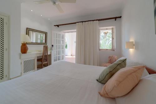 塔里法Hurricane Beach Hotel的卧室配有一张白色大床和一张书桌