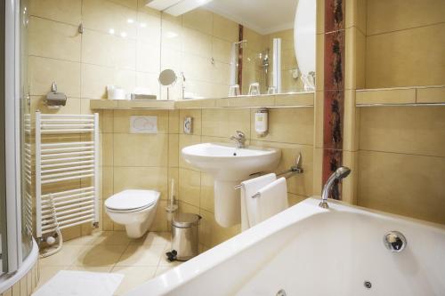 罗斯诺夫·波德·拉德霍斯滕艾尔罗普兰康体酒店的带浴缸、卫生间和盥洗盆的浴室