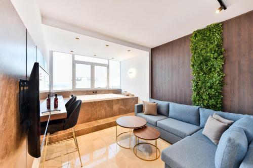 塞萨洛尼基Porto Sea View Apartments的客厅配有蓝色的沙发和电视