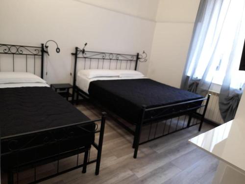 热那亚Affitta Camere La Turandot的一间卧室设有两张床和窗户。