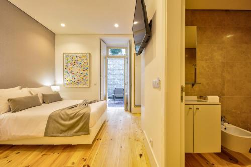 科英布拉Avenue Garden的一间卧室配有一张床、一个浴缸和一台电视。