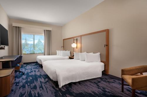 米苏拉Fairfield Inn & Suites by Marriott Missoula Airport的酒店客房配有两张床和一张书桌