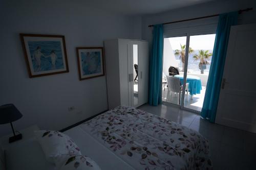 蓬塔穆赫雷斯Casa La Seba的一间卧室设有一张床,并有通往庭院的门