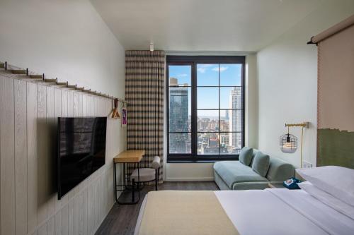 纽约纽约市切尔西慕奇夕酒店的一间卧室配有一张床、一张沙发和一台电视。