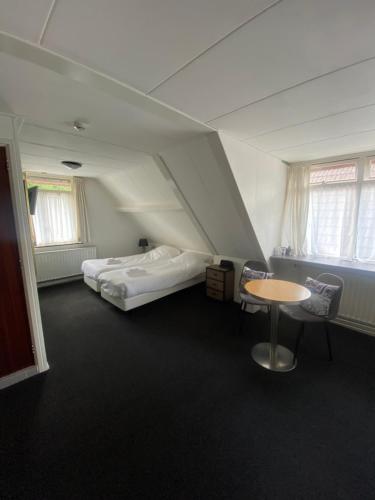 AaldenHet Wapen van Aelden的一间设有两张床和一张桌子及椅子的房间