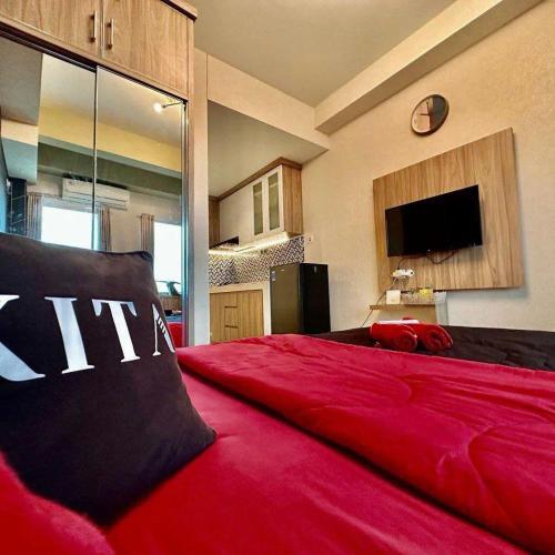 贝克西Patraland Urbano by Red Promo的一间配有电视的客房内的一张红色大床