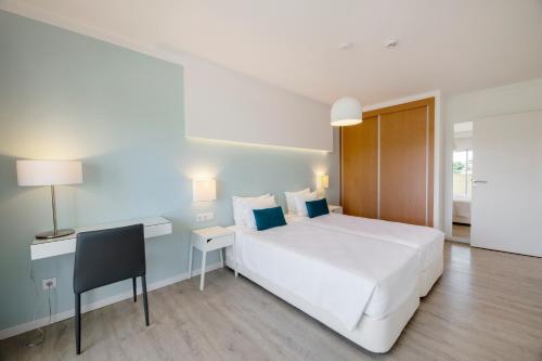 阿尔沃尔阿尔沃图瑞斯提克斯酒店的卧室配有一张白色大床和一张书桌