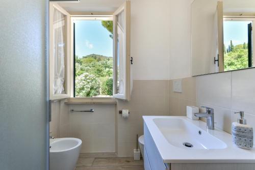 普罗基奥Casa Camilla的白色的浴室设有水槽和窗户。