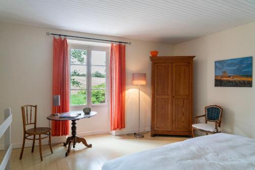 纳雅克Maison Fauvel, Natur pur的一间卧室配有一张床、一张桌子和一个窗户。