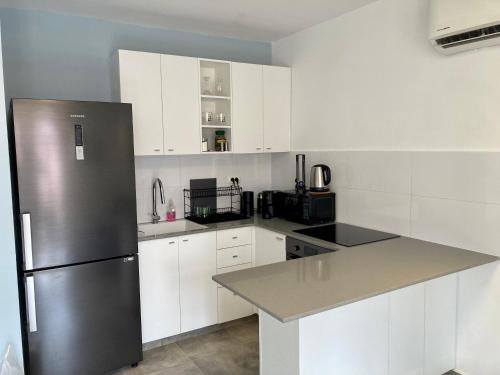 耶路撒冷Lovely New Private Duplex in Prime City Center location的厨房配有白色橱柜和不锈钢冰箱