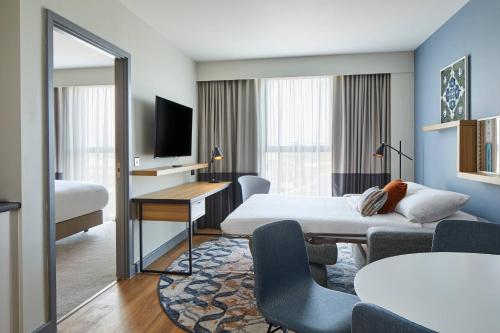 斯劳Residence Inn by Marriott Slough的配有一张床和一张书桌的酒店客房