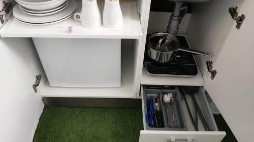 瓦伦西亚Small and Cozy Rooms - G10的厨房配有带盘子和餐具的白色橱柜