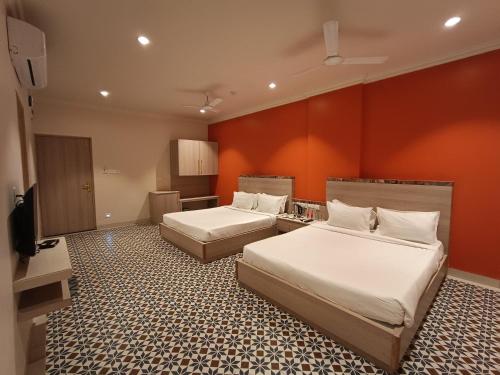 那格浦尔Bougainvillea Banquets and Convention Centre的酒店客房设有两张床和一台平面电视。