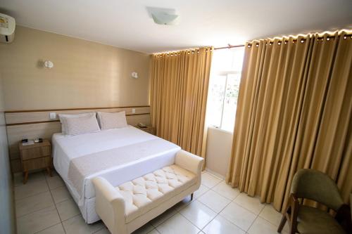 Sobradinho阿尔维马尔酒店的卧室配有白色的床和窗户。