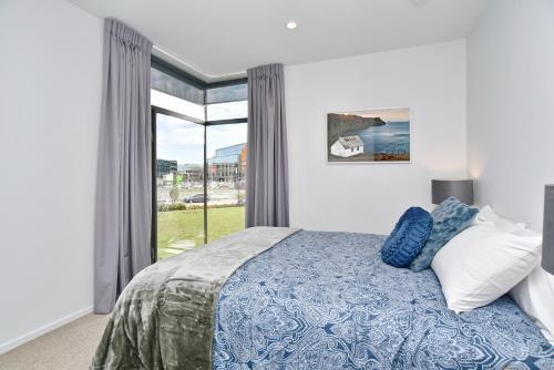 基督城Lichfield Apartment - Christchurch Holiday Homes的一间卧室设有一张床和一个大窗户