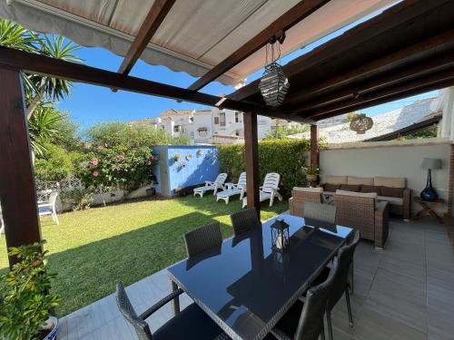 卡拉德米哈斯Beach and Golf House La Cala de Mijas的一个带桌椅的庭院和一个花园