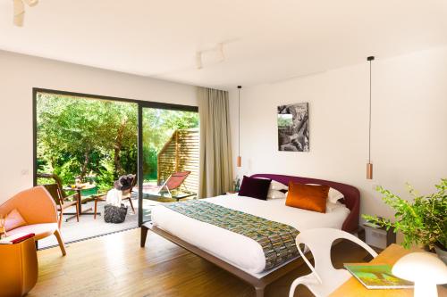 博尼法乔Hôtel & Spa Version Maquis Citadelle的一间卧室设有一张床和一个滑动玻璃门