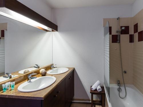 贝尔热拉克Apartment in a picturesque city in the Dordogne的浴室配有2个盥洗盆、淋浴和浴缸。