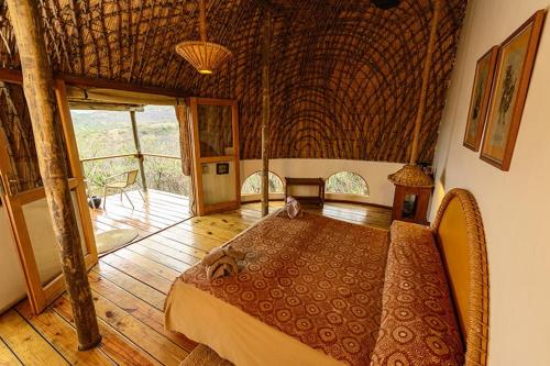 丹地Kingdom Game Ranch的一间铺有木地板的客房里设有一张床的卧室