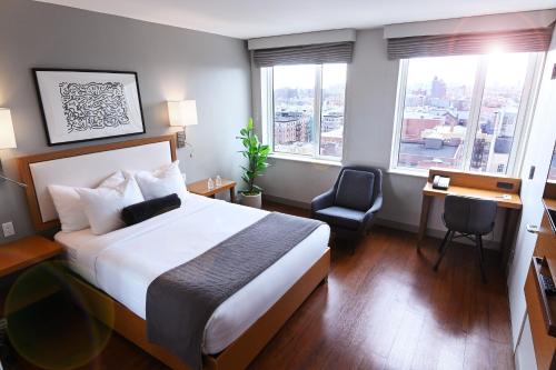 纽约华盛顿高地边缘酒店的酒店客房设有一张床、一张书桌和窗户。