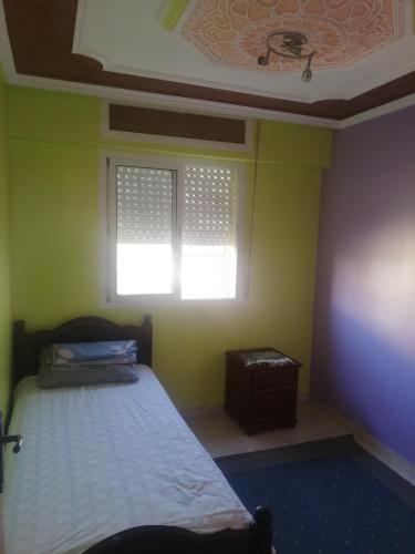 Appartement Boekidan/Al houceima的一间卧室设有一张床和一个窗口