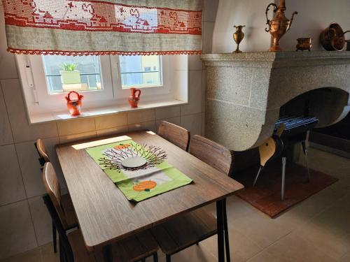 弗雷舒德埃什帕达阿辛塔Casa da Avó Aninhas的客房内的木桌、椅子和壁炉