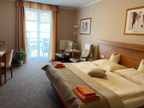 弗兰季谢克矿泉镇LD PALACE Spa & Kur的酒店客房,配有一张大床,上面有橙色毛巾