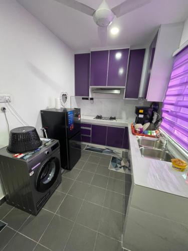 北根Homestay Azirah-musleem preferred的厨房配有紫色橱柜和洗衣机