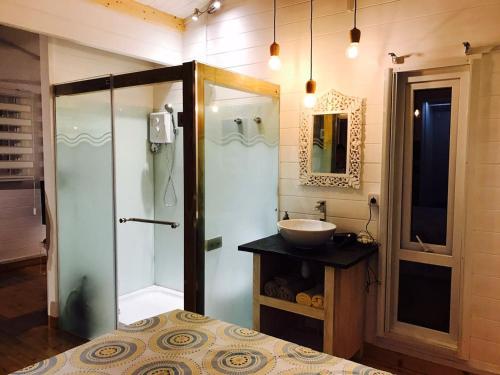 塔马兰Between2Waters Chalet rental car offered的一间带玻璃淋浴和水槽的浴室