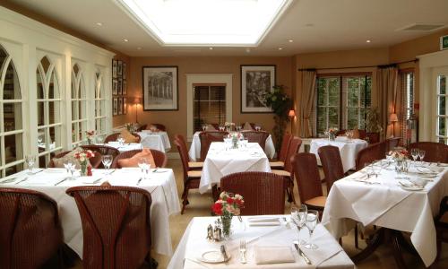 科姆里皇家酒店的餐厅配有桌椅和白色的桌布