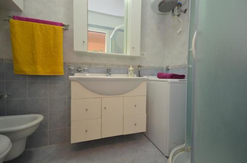 利尼亚诺萨比亚多罗奥林波公寓的一间带水槽、镜子和卫生间的浴室