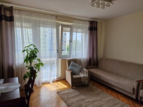 罗兹APARTAMENT zielona Retkinia - blisko ZOO, Atlas Arena, Mandoria, S14, Lotnisko的带沙发和窗户的客厅