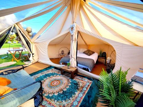 诺丁汉Bell Tent Village的帐篷内的卧室,配有一张床和地毯