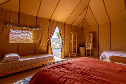El KariaAgafay, La Ferme Nomade Bivouac的帐篷内一间卧室,配有一张床