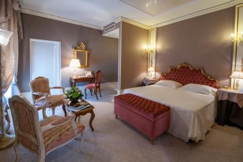 威尼斯萨赛格雷多酒店的卧室配有一张床和一张桌子及椅子