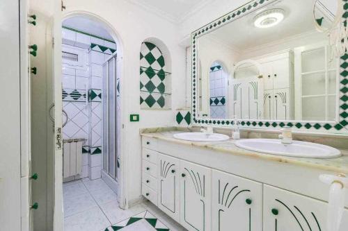 贝加德圣马特奥Villa Ojuelos的一间带两个盥洗盆和大镜子的浴室