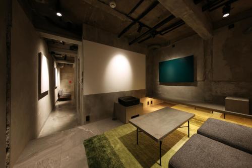 京都SHIN kyoto的客厅配有沙发和墙上的电视