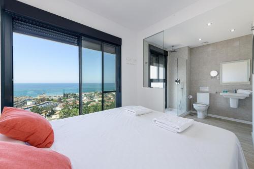 托雷德本纳贾尔邦WintowinRentals New and Sea View的一间带白色大床的卧室和一间浴室