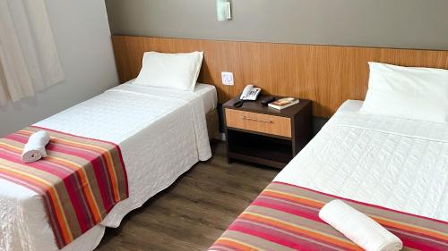 伊达贾伊Itajaí Express Residence的酒店客房设有两张床和一张桌子上的电话