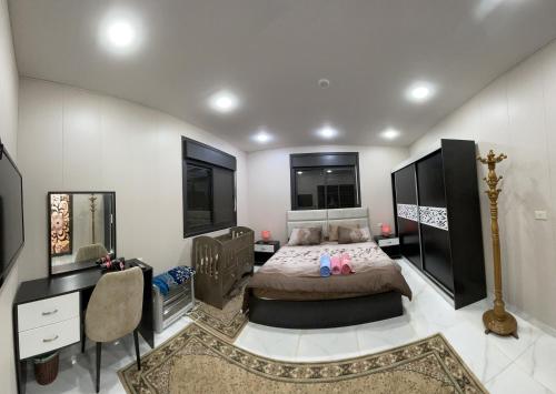 杰拉什Abu Hossam s chalet的一间卧室配有一张床、一张桌子和一张四柱床。