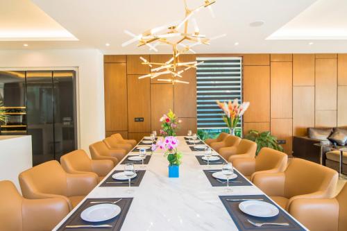 岘港Ocean Villa Pool Retreat In Da Nang的长长的用餐室,配有长桌子和橙色椅子