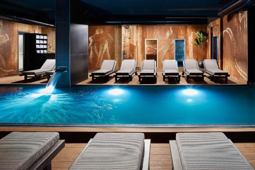 兹拉蒂博尔21st Century Zlatibor Residence, Spa & Wellness by Adora的等候室里带椅子的游泳池