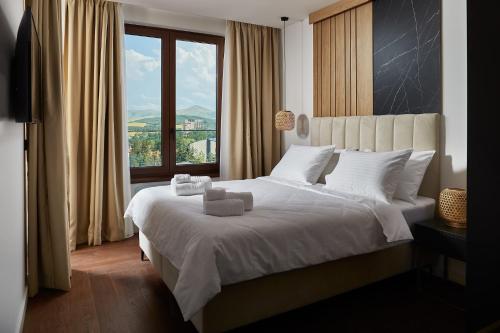 兹拉蒂博尔21st Century Zlatibor Residence, Spa & Wellness by Adora的一间卧室设有一张大床和大窗户